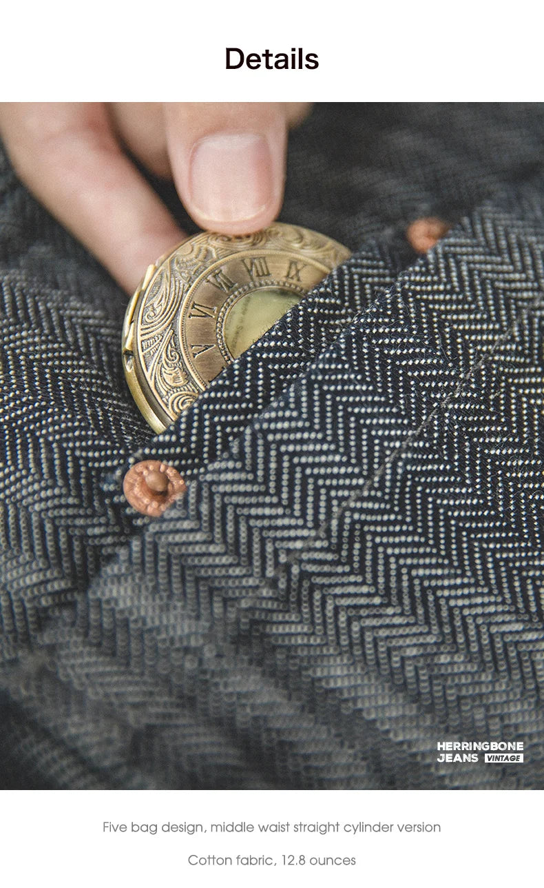 Hand holding a decorative coin over a textured fabric surface with 'Herringbone Jeans' branding.
