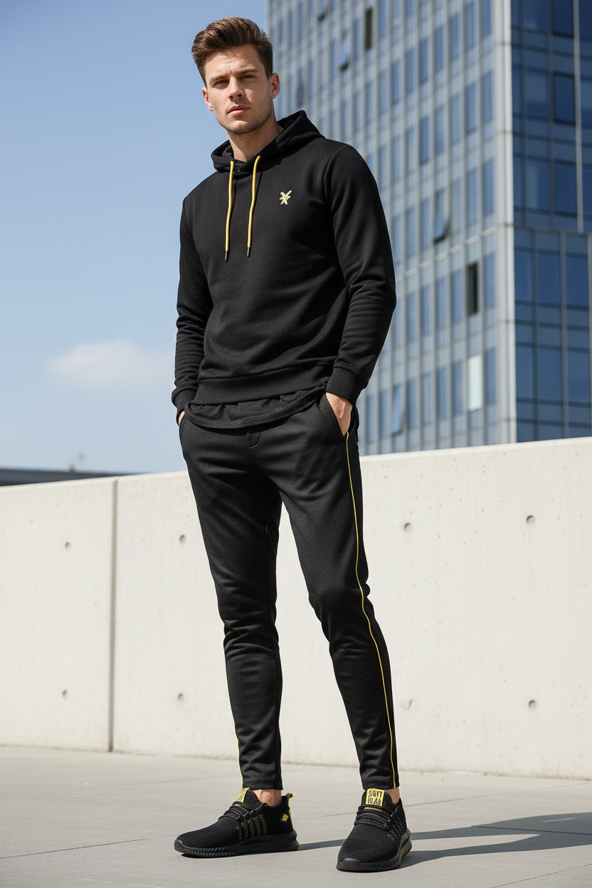 Black athletic shoe with yellow accents on a white background