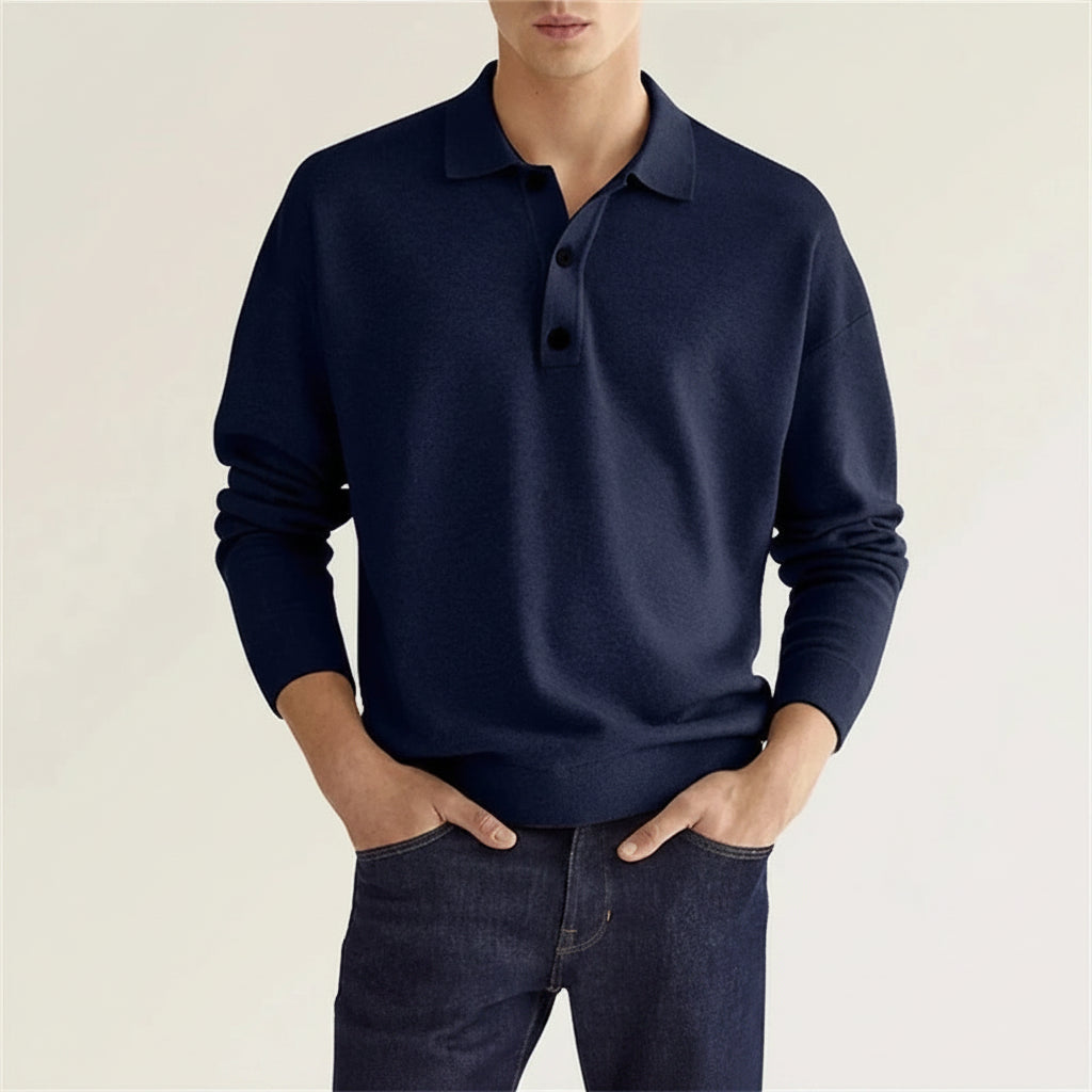 Person wearing a navy blue sweater with a plain background