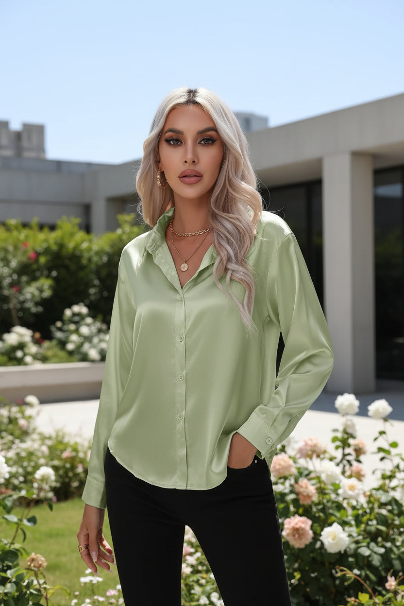 Woman wearing a light green satin shirt against a white background