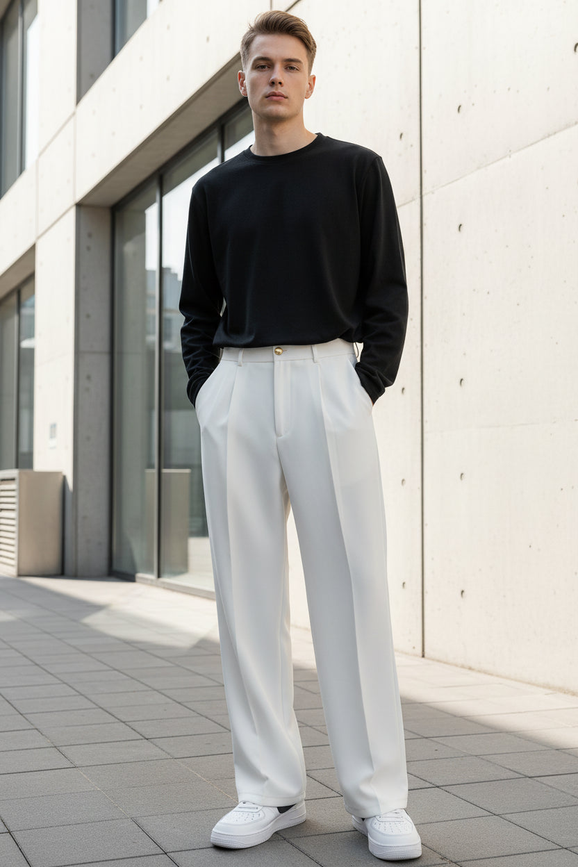 Person wearing white wide-leg pants and a black top in a minimalistic setting.