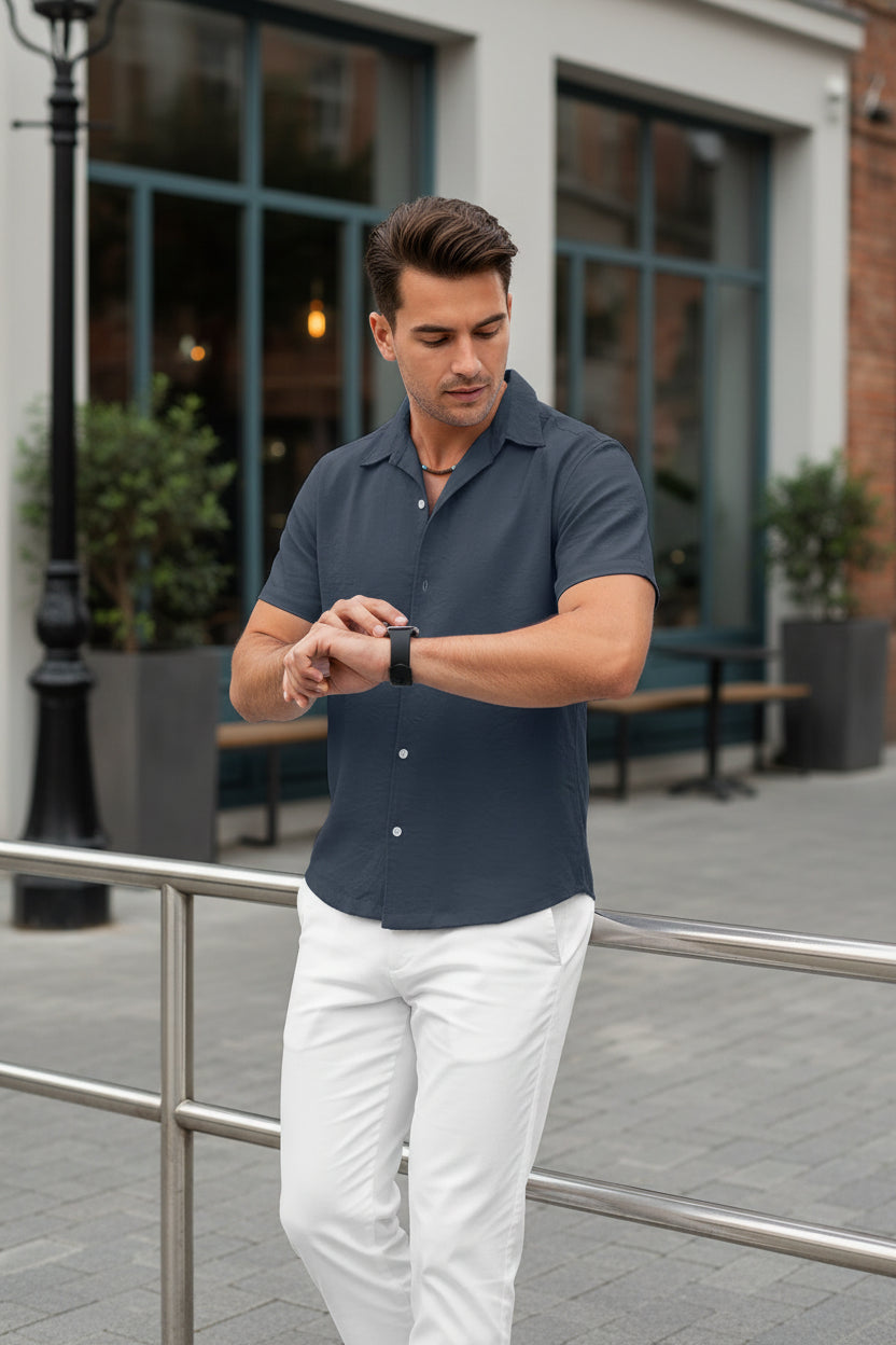 Man wearing a dark blue short-sleeve shirt outside