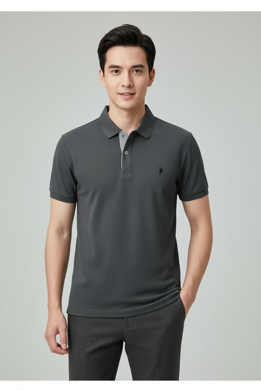 Gray polo shirt with a brand logo held by a hand, with other shirts in the background.