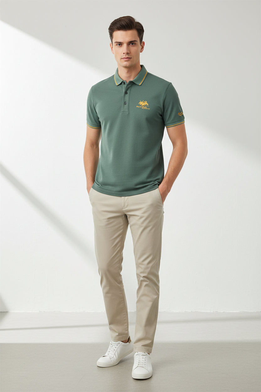 Green polo shirt with gold accents on a dark surface, featuring a brand logo.
