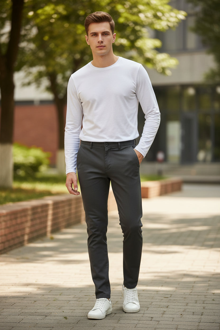 Person wearing dark gray pants and brown shoes on a gray background
