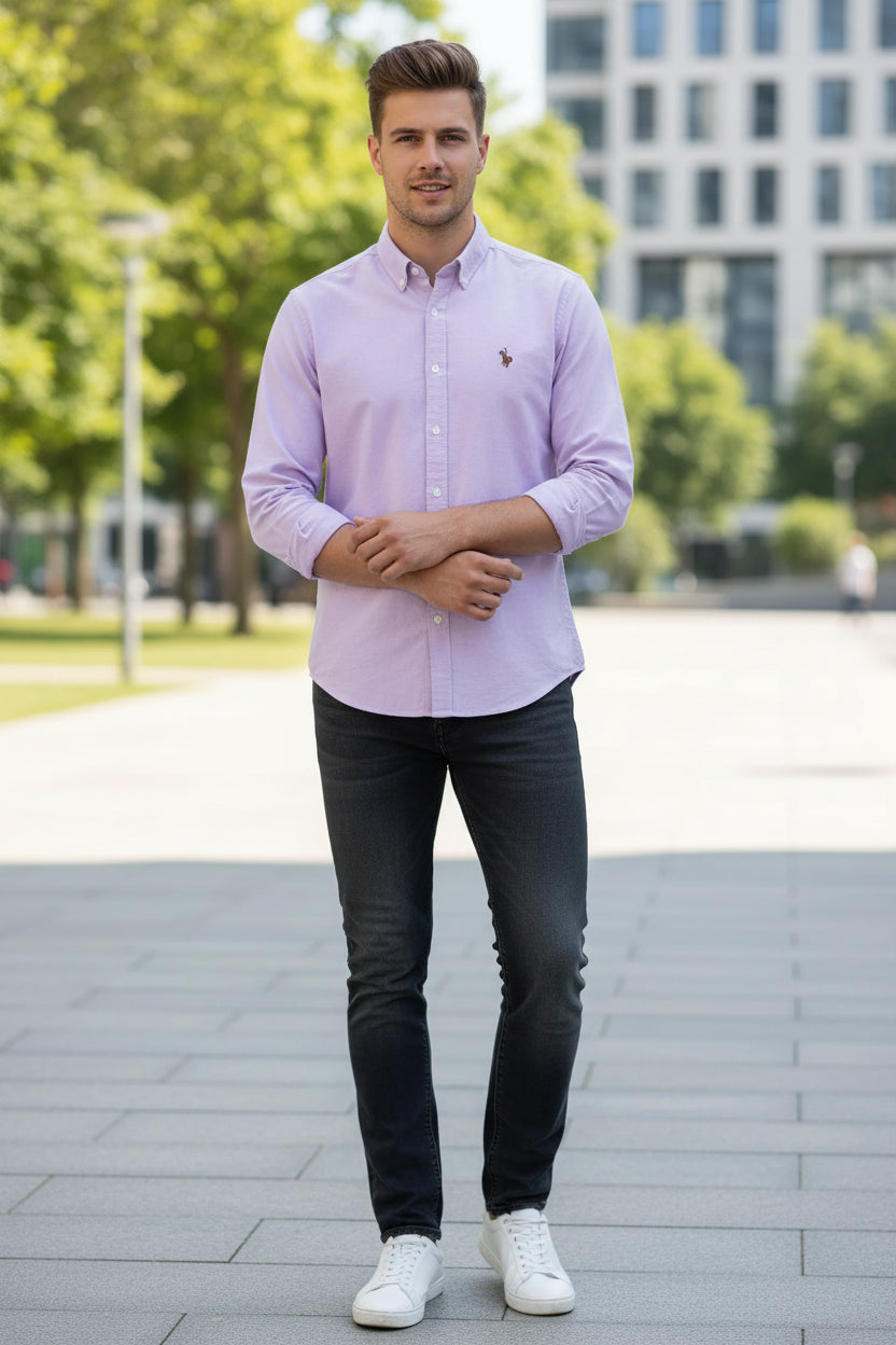 Folded light purple shirt with a logo on a gray surface