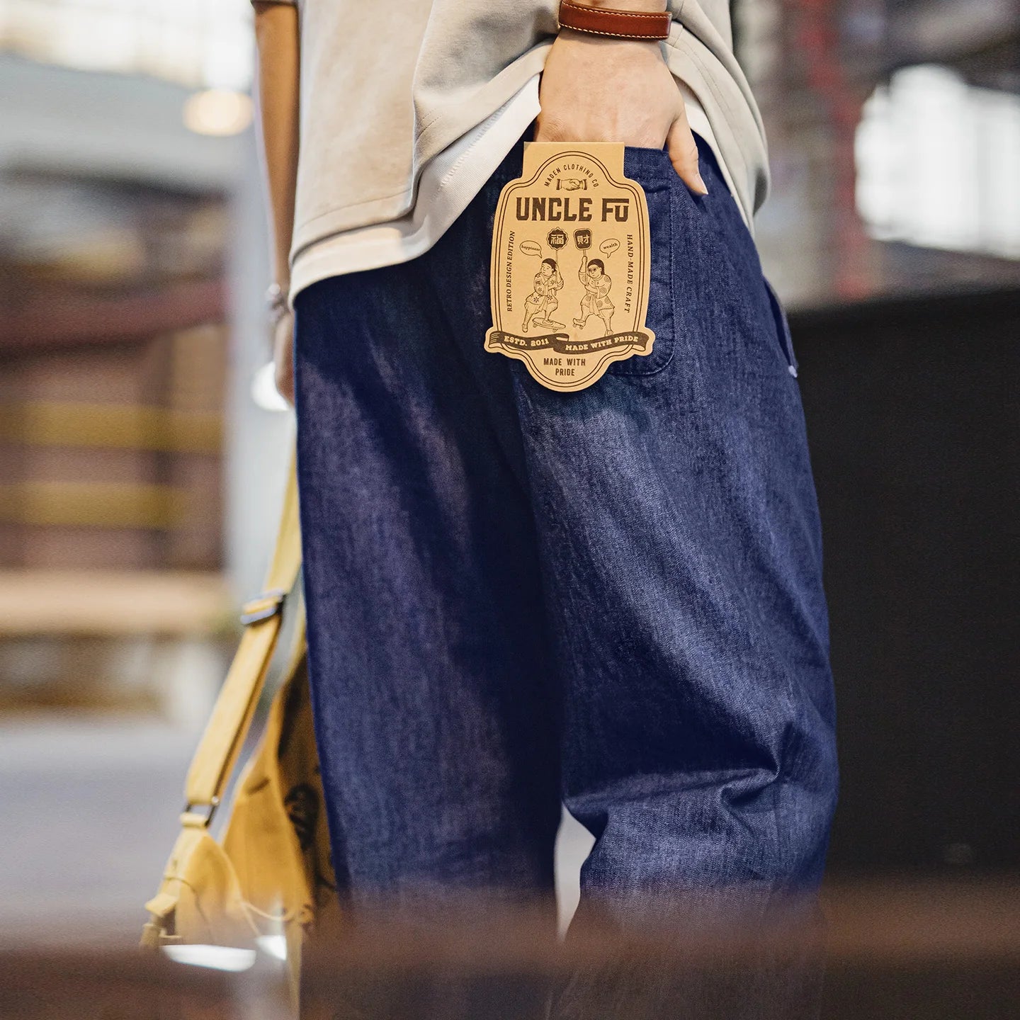 Person wearing blue jeans with a 'Uncle Fo' label on a blurred background