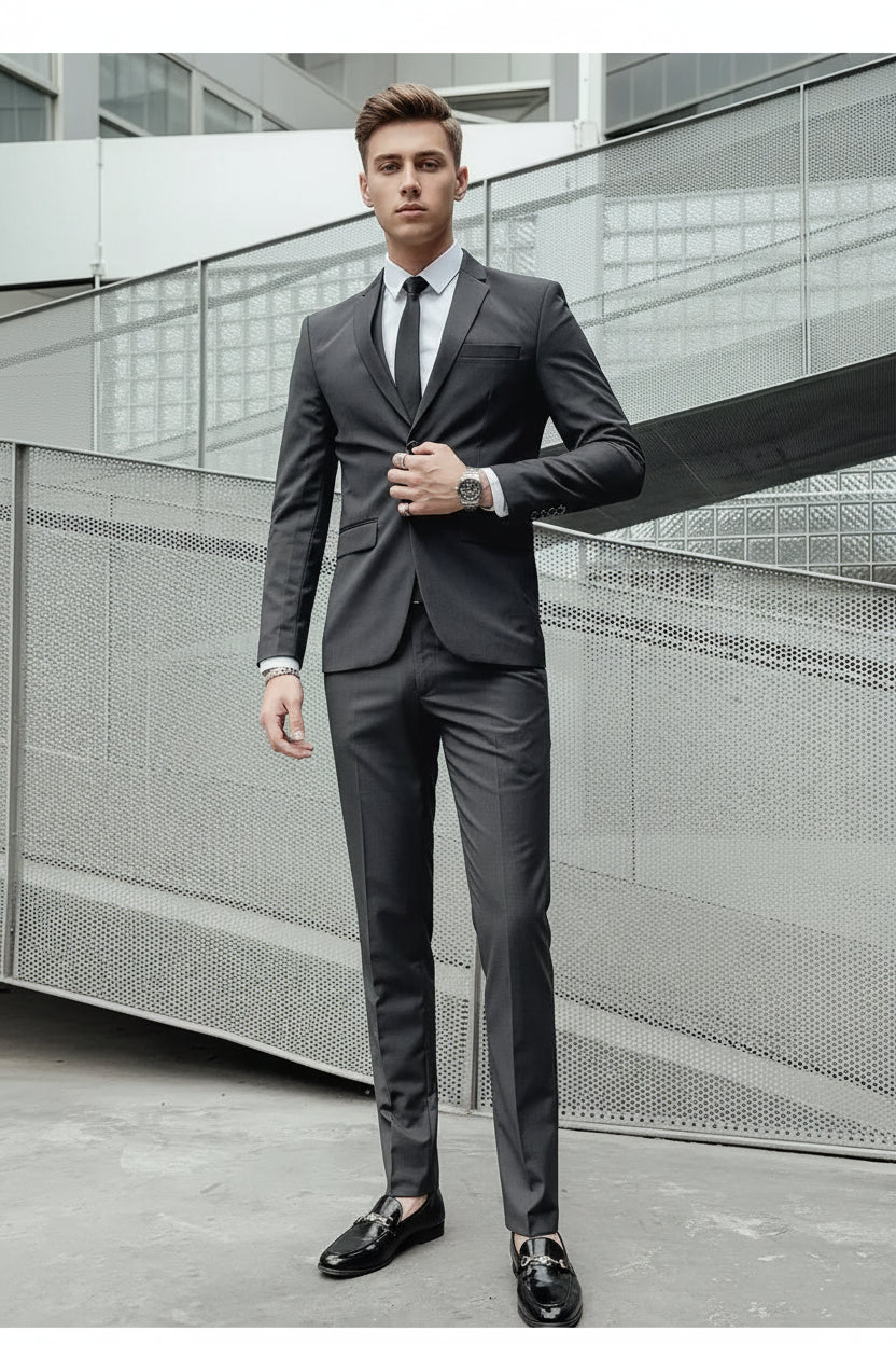 Man in a gray suit standing against a modern architectural background
