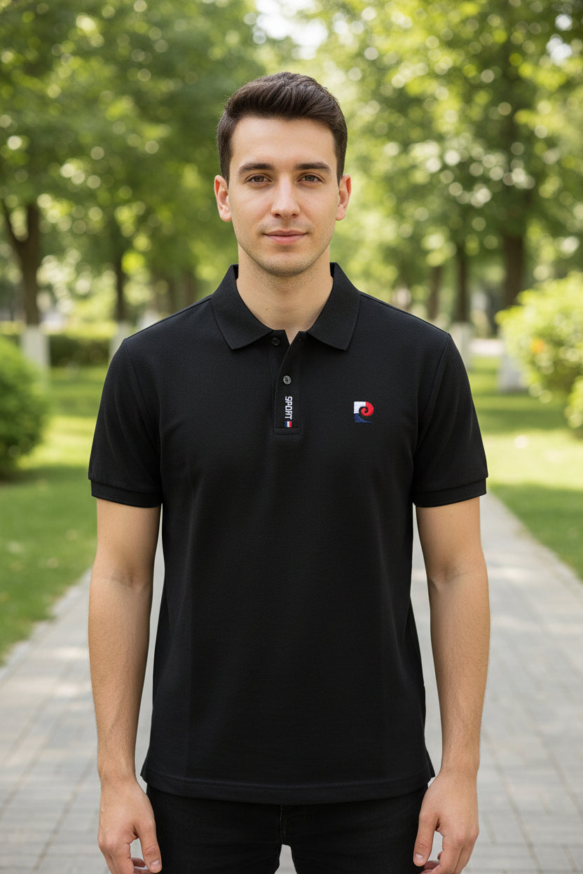 Black polo shirt with brand logo held by a hand against a blurred clothing store background