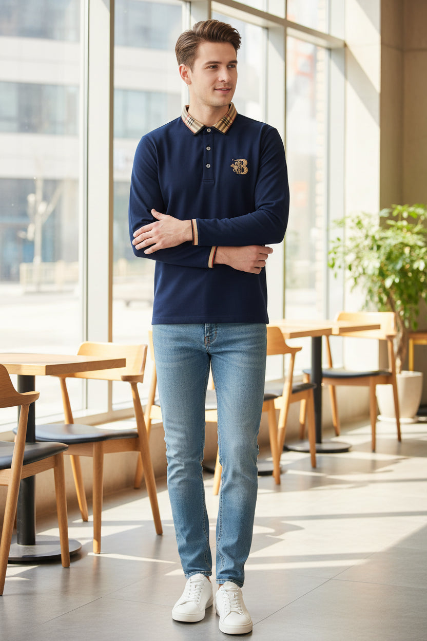 Navy blue polo shirt with beige plaid collar and brand logo on a gray surface.