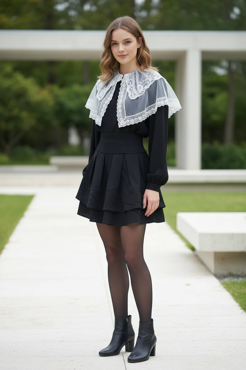 Black outfit with white lace detailing on a plain background