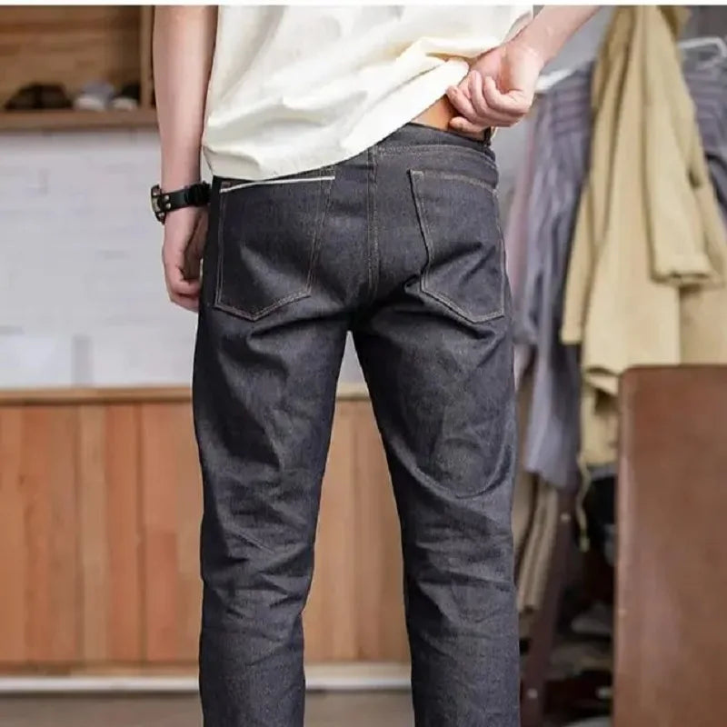 Person wearing dark gray pants in a room with wooden furniture and clothes in the background