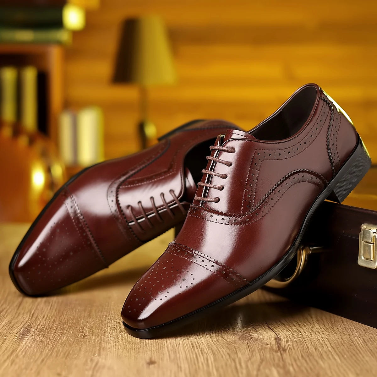 Pair of brown dress shoes on a wooden surface with a blurred background