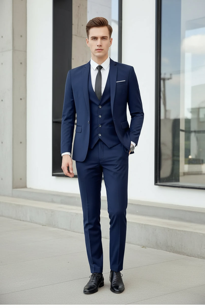 Man wearing a blue suit with a white shirt and black tie indoors.