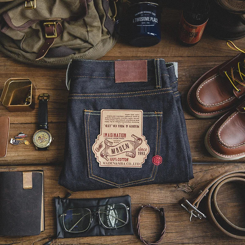 Blue jeans with a brand label on a wooden surface with accessories.