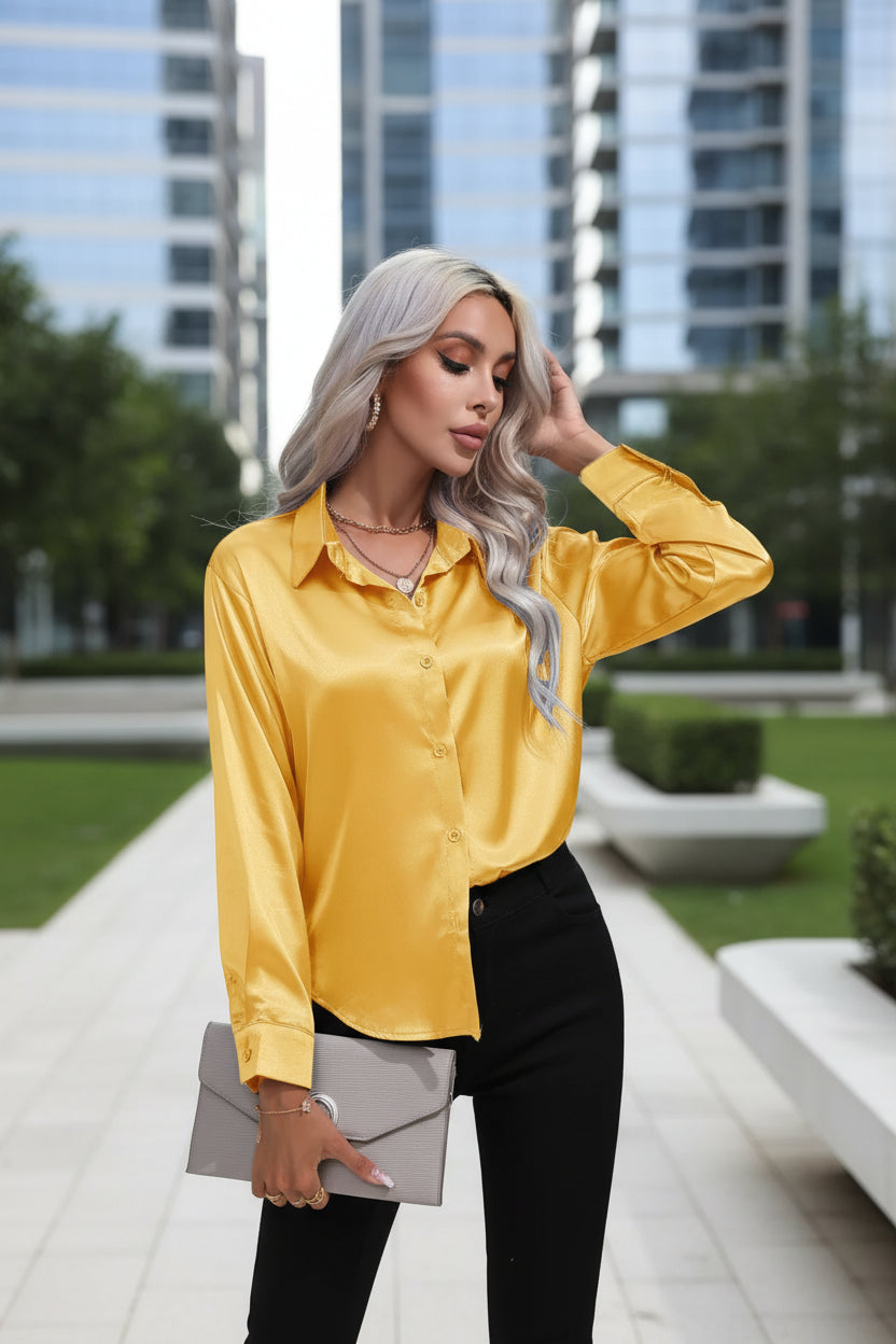 Woman wearing a yellow satin shirt with black pants on a white background