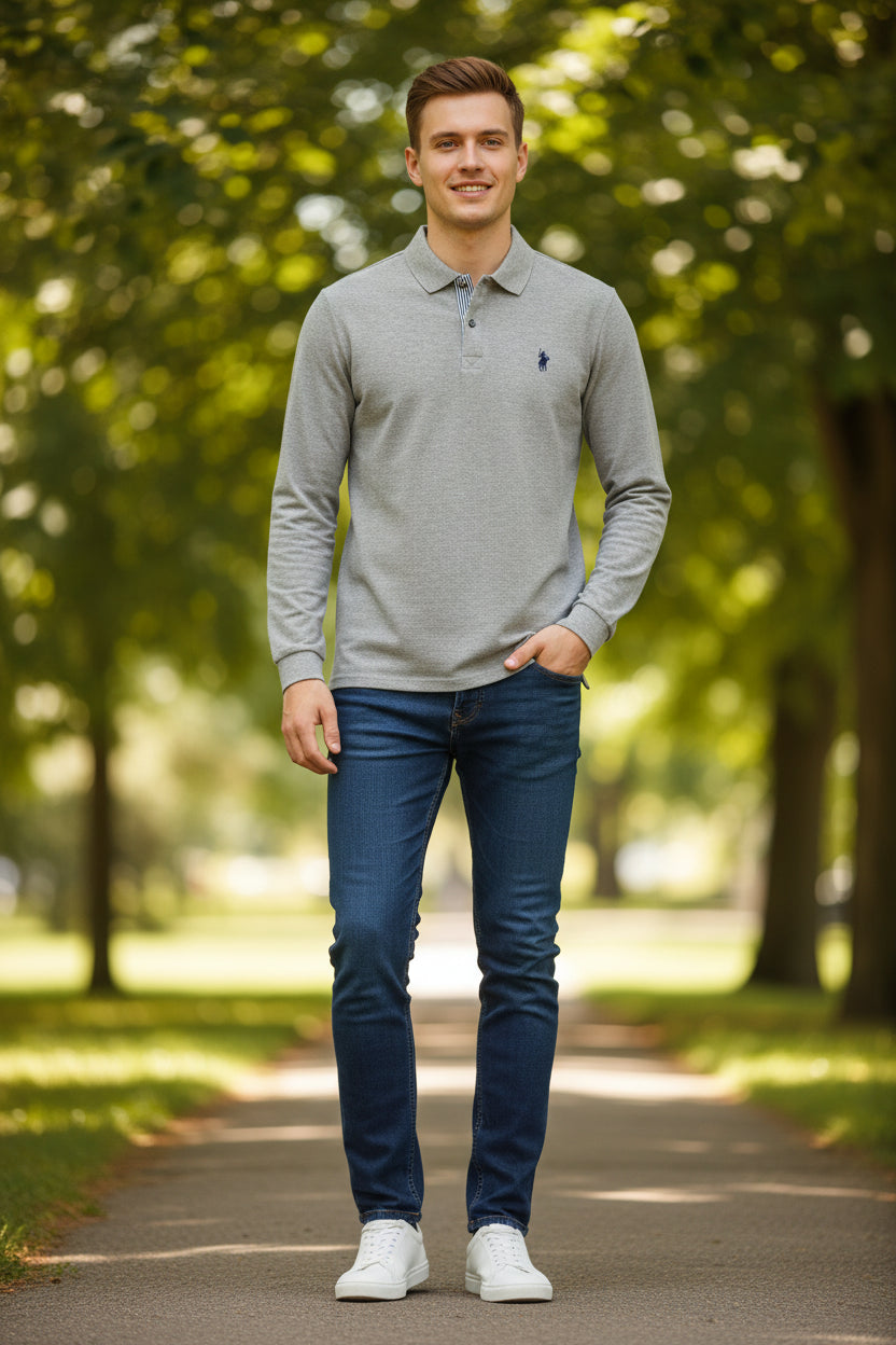 Gray long-sleeve polo shirt with a brand logo on a hanger in a clothing store.