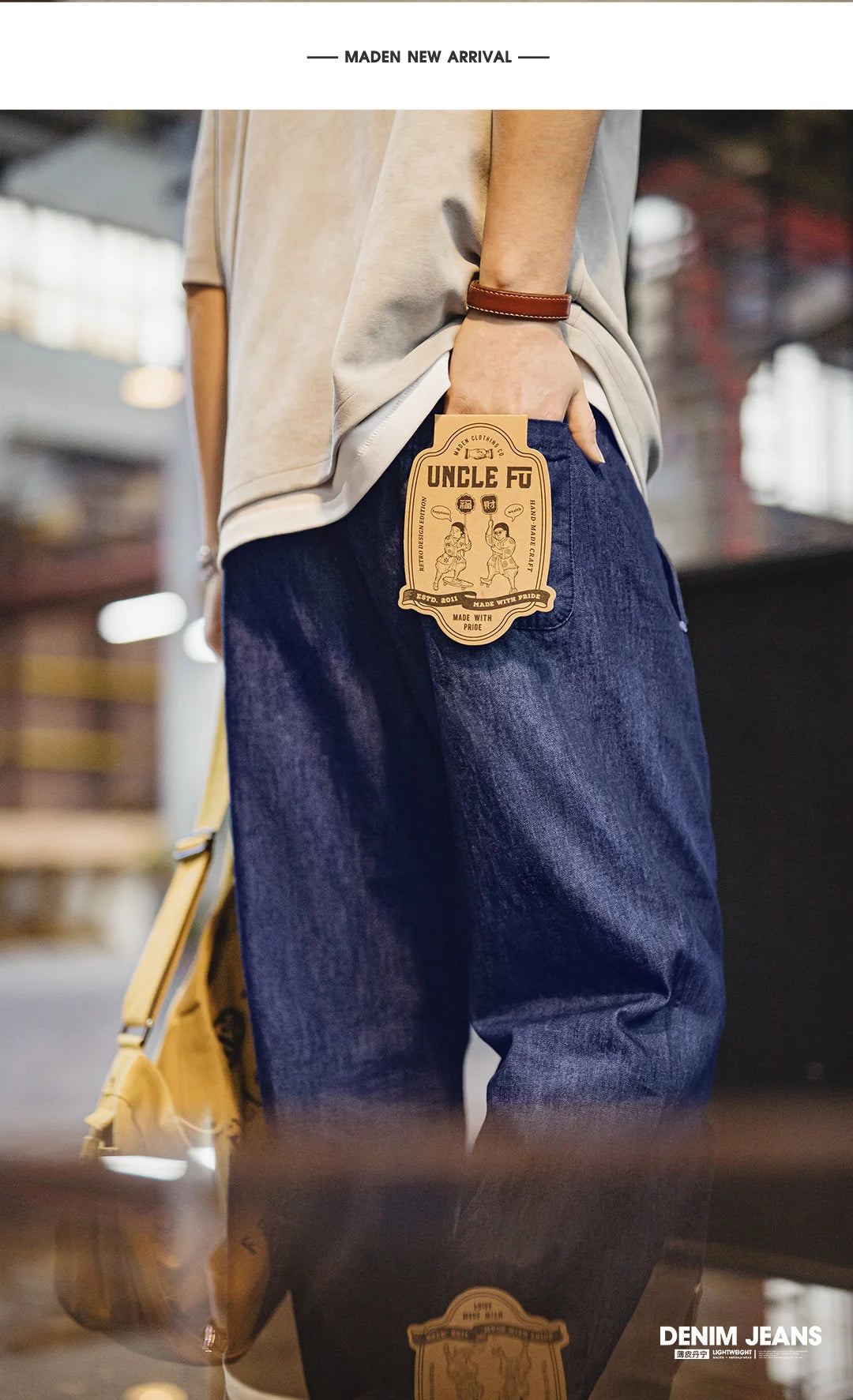 Person wearing blue denim jeans with a visible brand tag, standing in an urban setting.