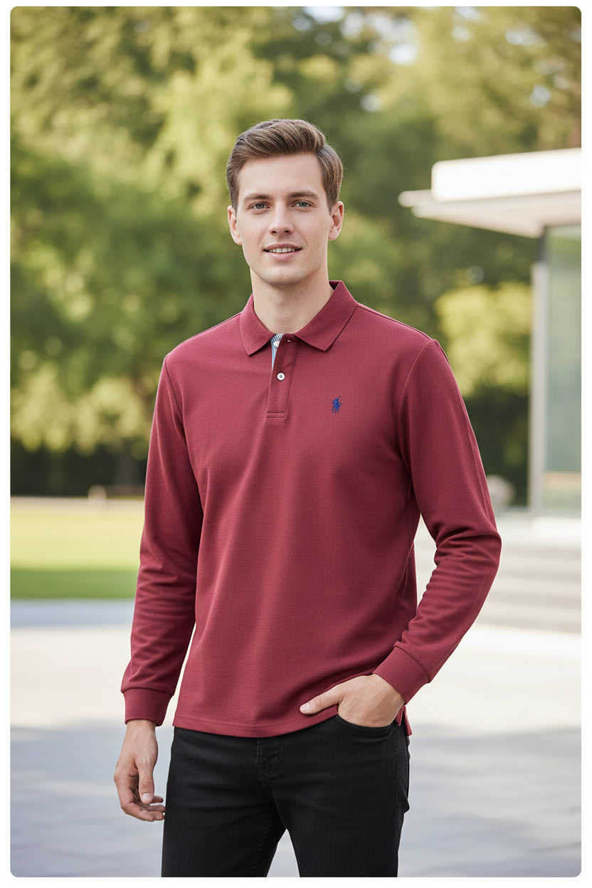 Red long-sleeve polo shirt with a small logo on a hanger against a background of other shirts.