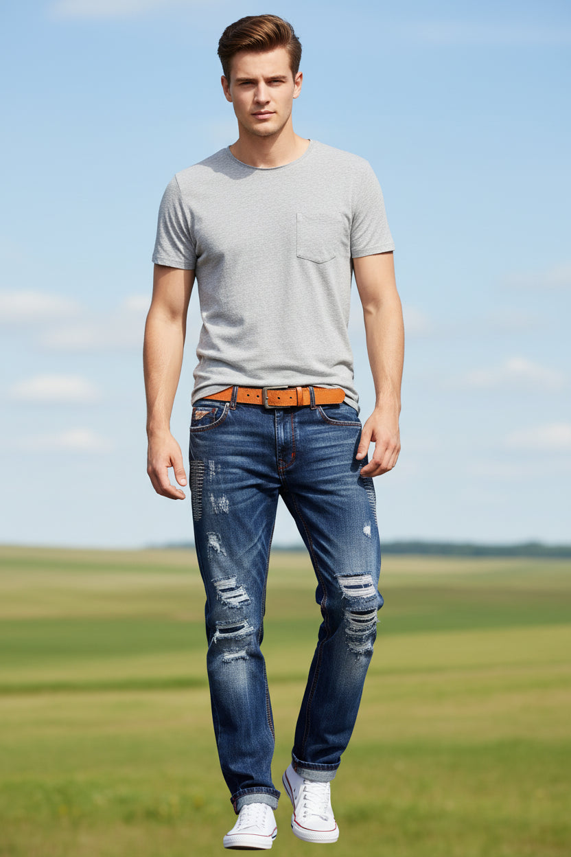 Blue jeans with an orange belt on a wooden floor and cloudy sky background