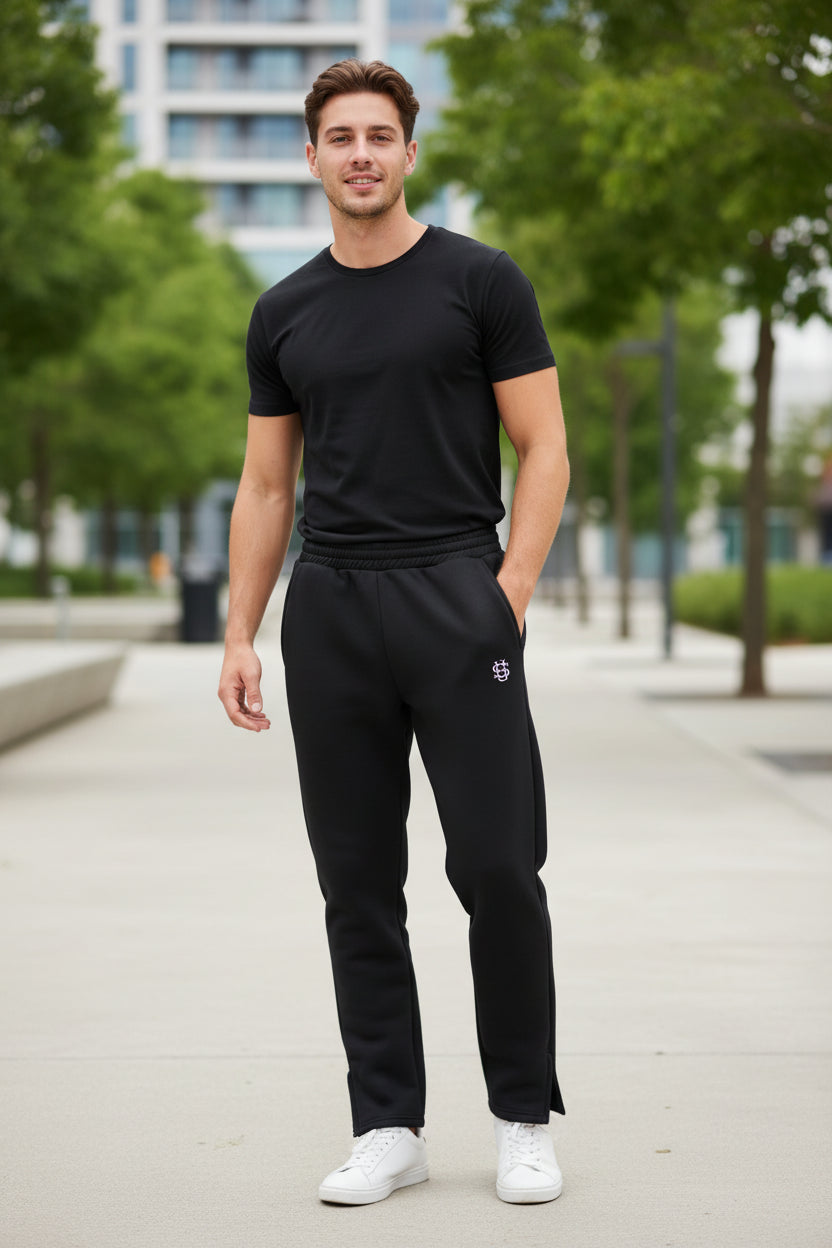 Black pants with a small logo on a textured concrete surface