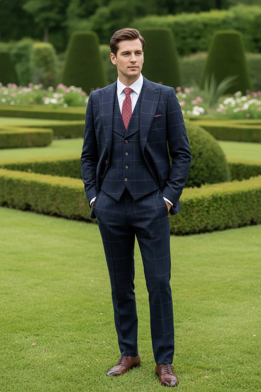Man wearing a navy checkered suit with a red tie in a garden setting