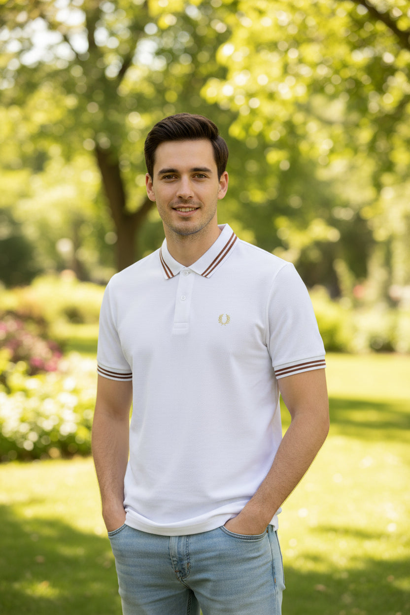 White polo shirt with brown trim held by a hand against a blurred background