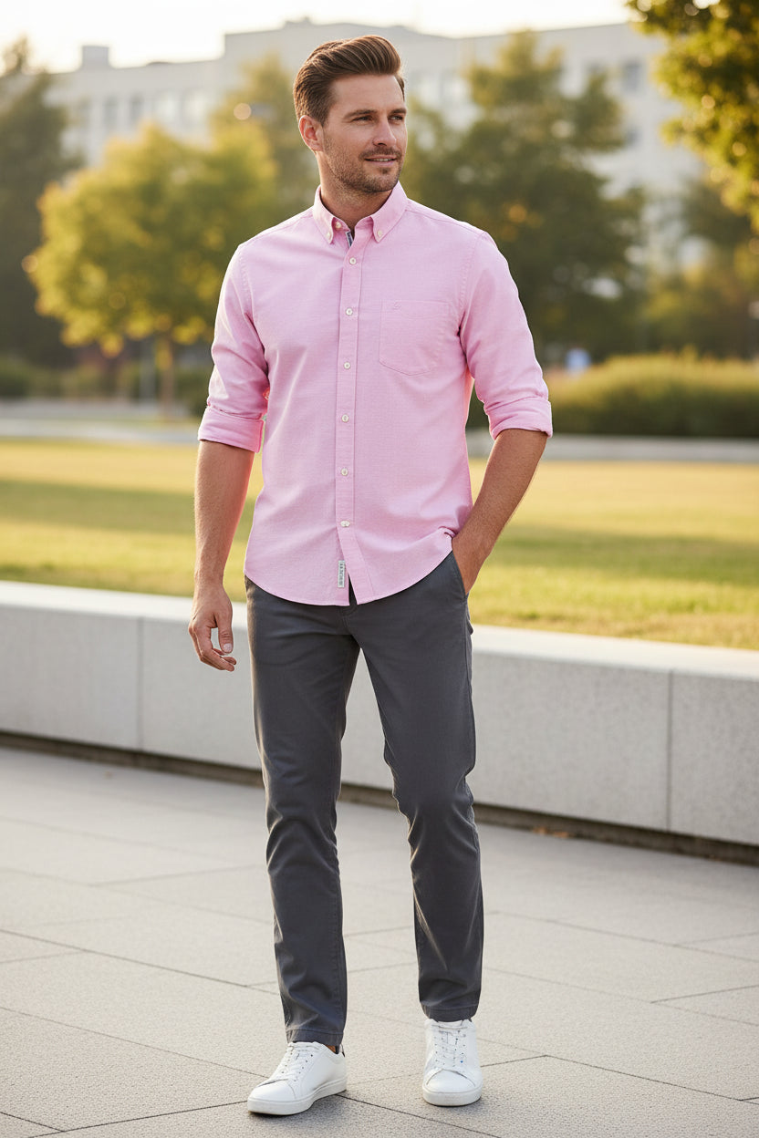 Folded pink shirt with a white background