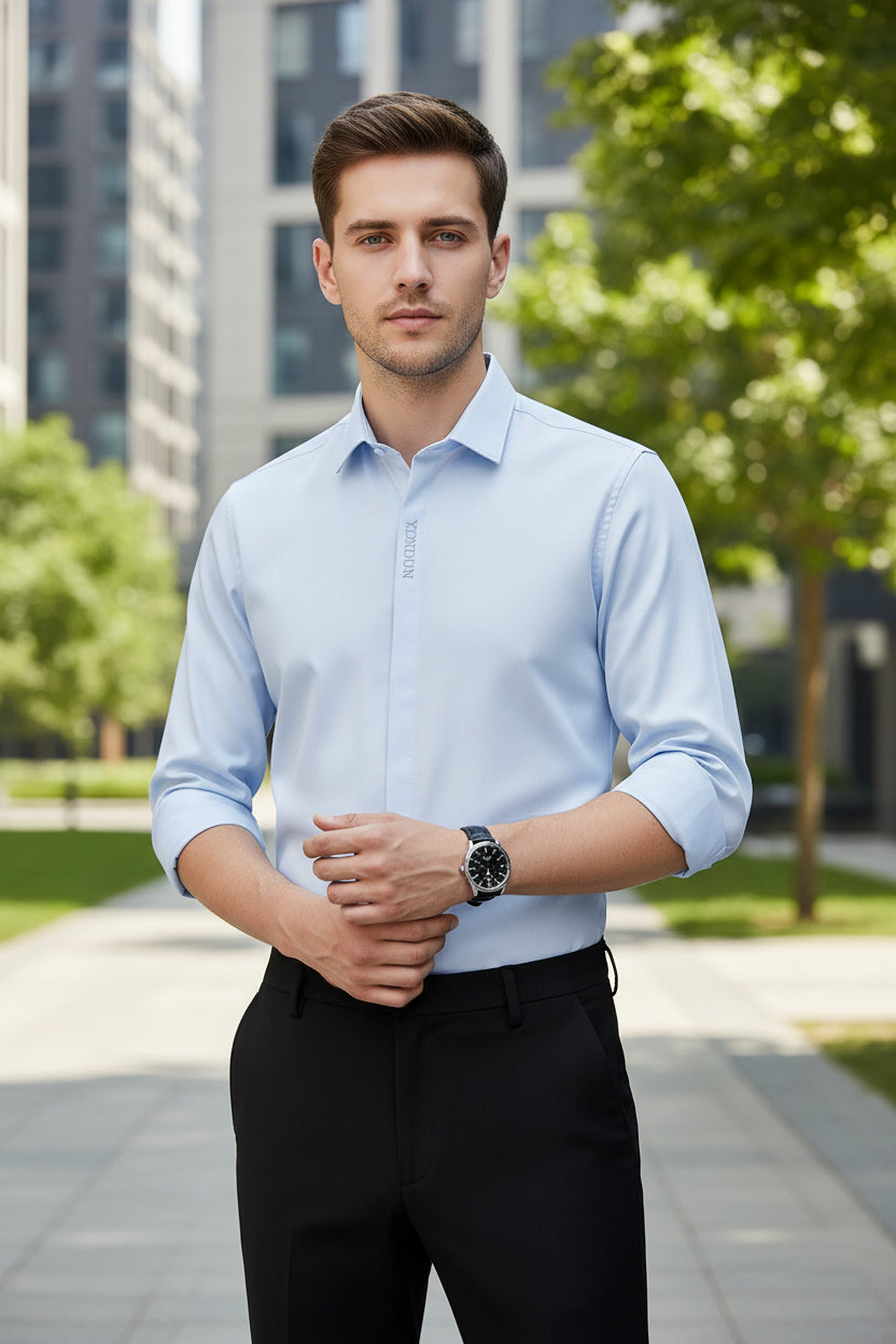 Light gray dress shirt with rolled-up sleeves worn by a person on a gray background