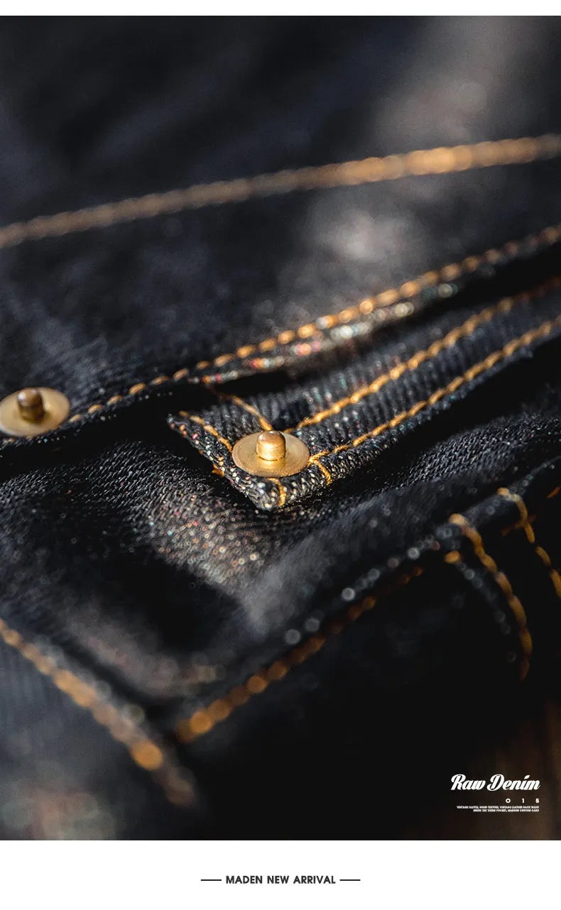 Close-up of a dark denim fabric with gold stitching and buttons, featuring the brand 'Raw Denim'.
