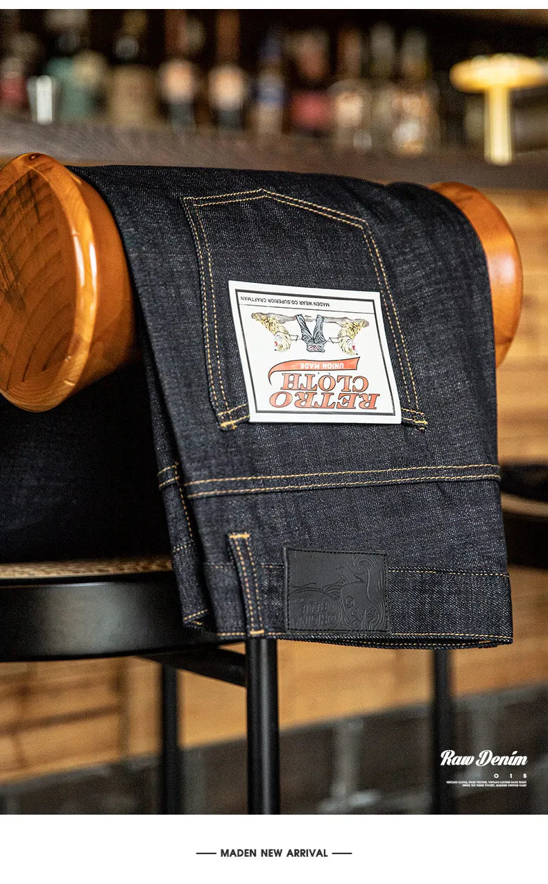 Dark denim jeans with a brand label on a wooden stool in a bar setting