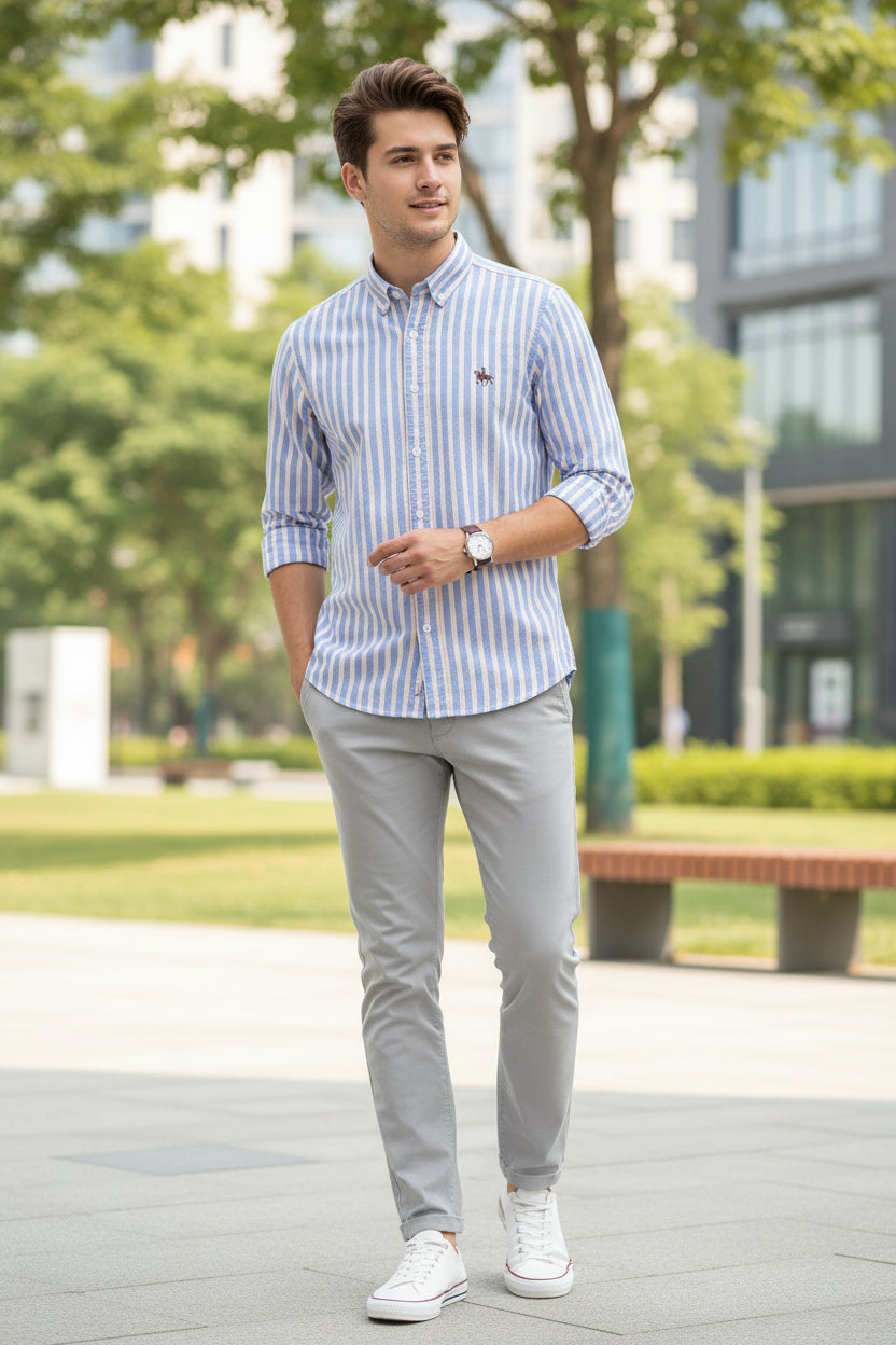 Folded blue and white striped shirt with a logo on a gray surface