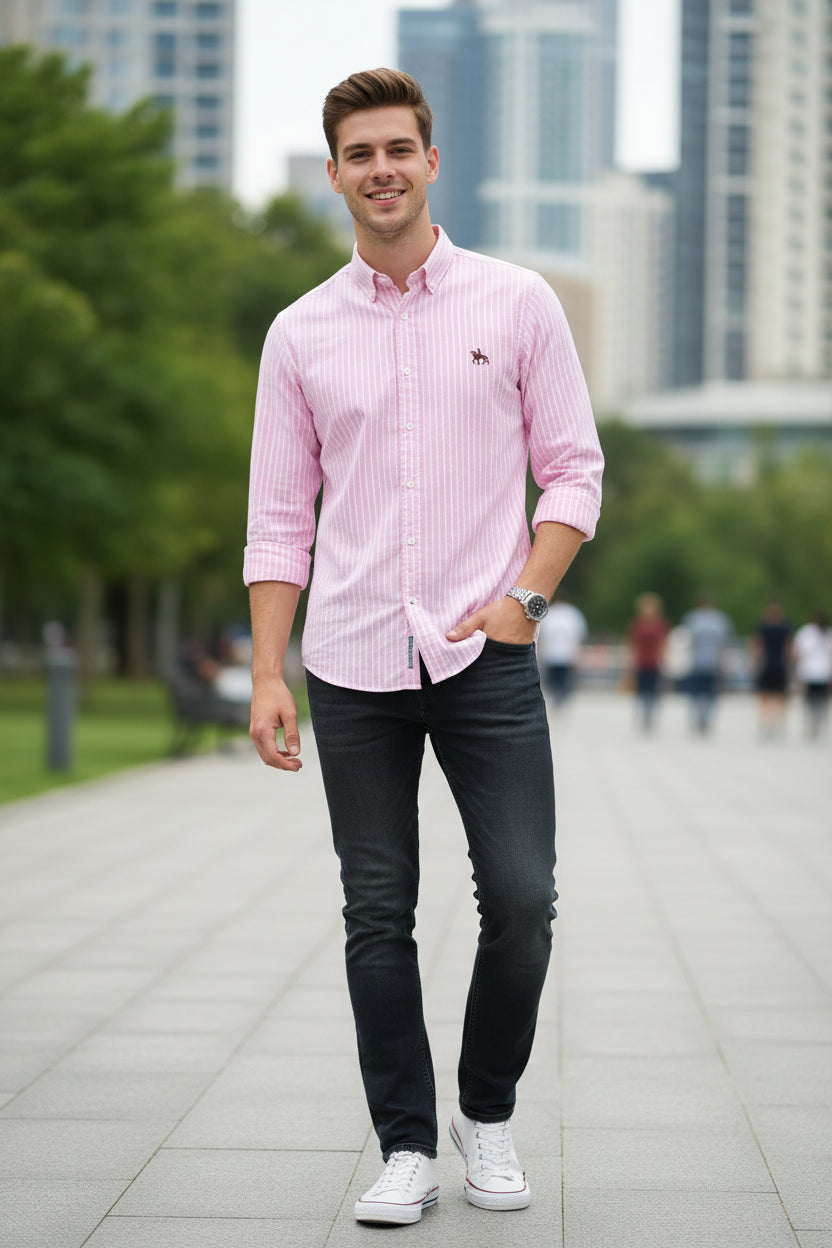 Folded pink and white striped shirt with a logo on a gray surface