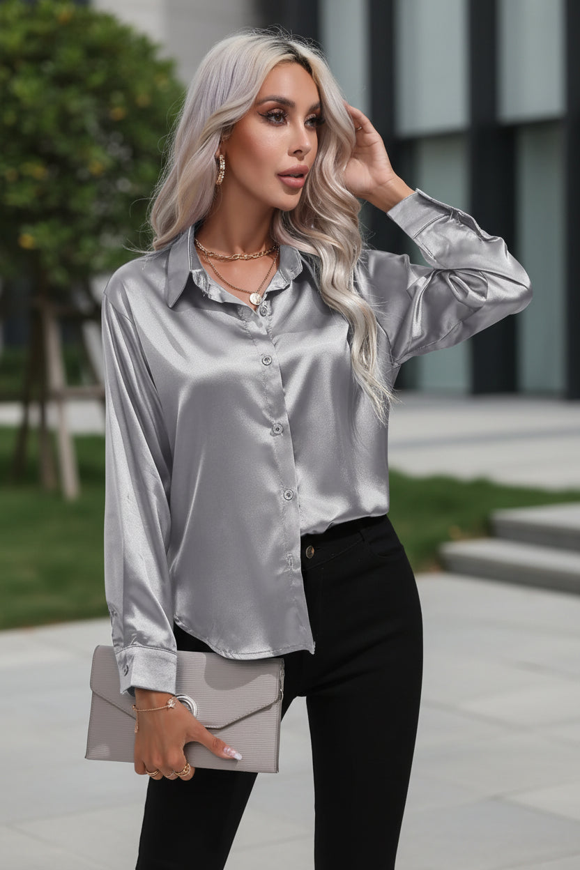 Woman wearing a silver satin shirt against a white background