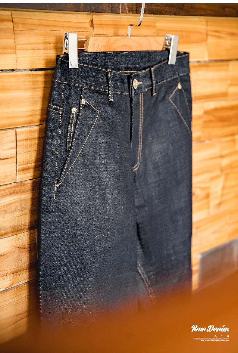 Denim pants hanging on a wooden wall with 'Raw Denim' branding.