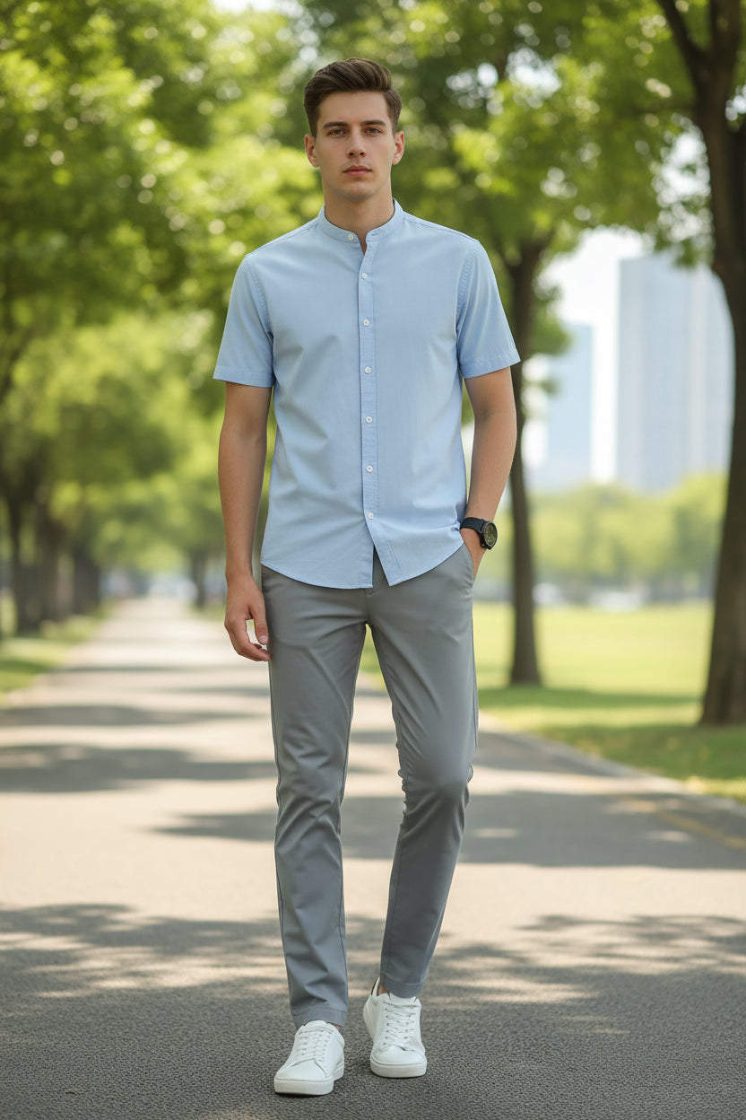 Person wearing gray pants and white sneakers on a gray background