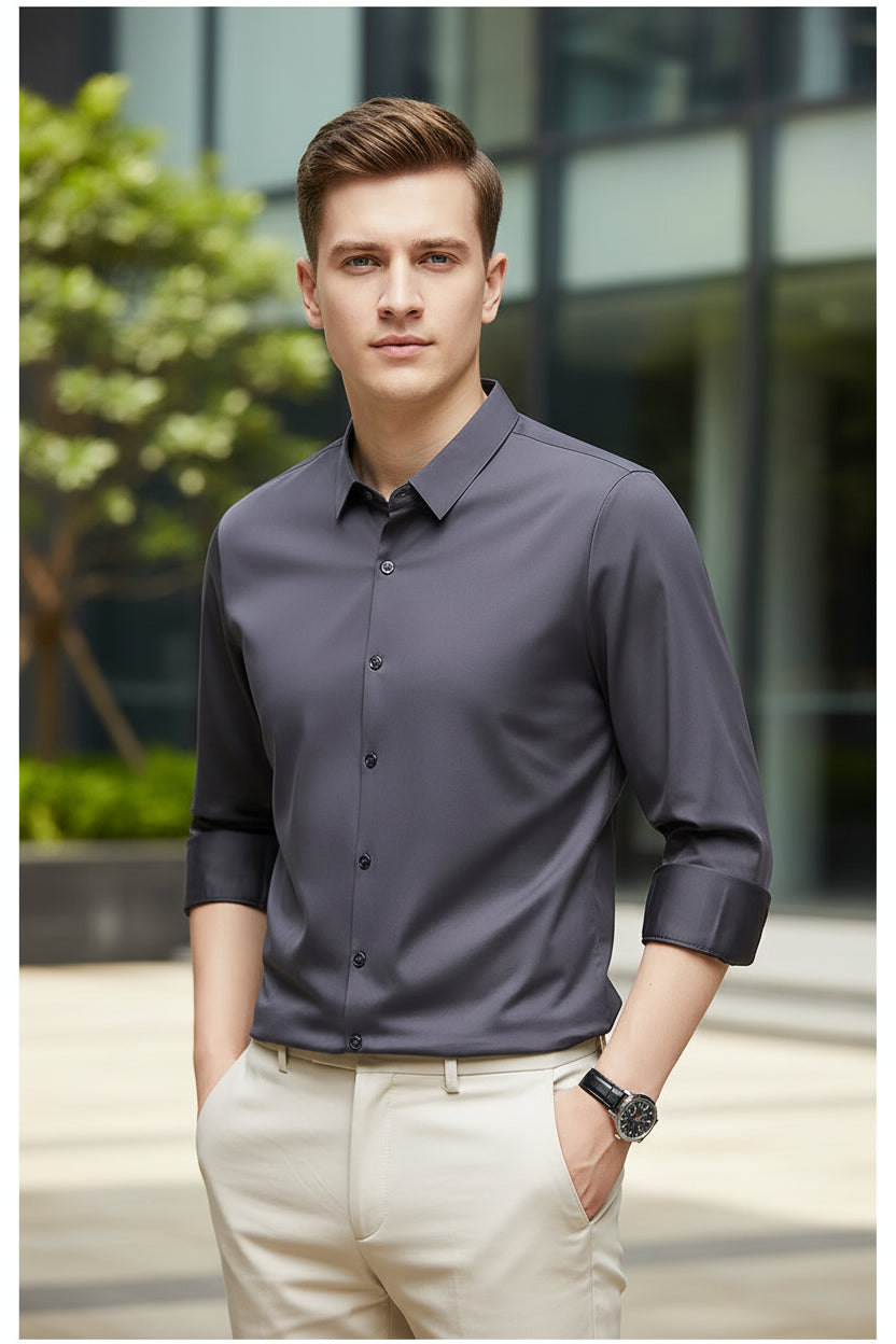 Gray dress shirt with rolled-up sleeves worn by a person on a black background