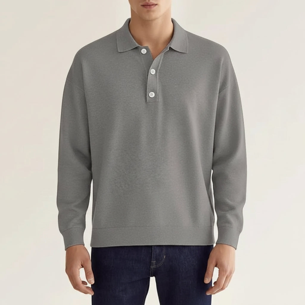 Person wearing a gray long-sleeve polo shirt against a plain background
