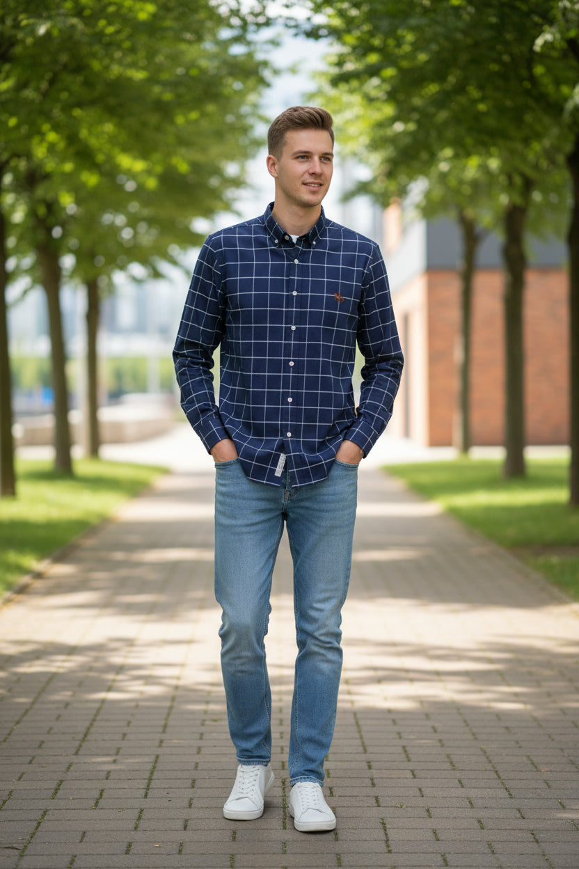 Folded blue checkered shirt with a small logo on a gray textured surface