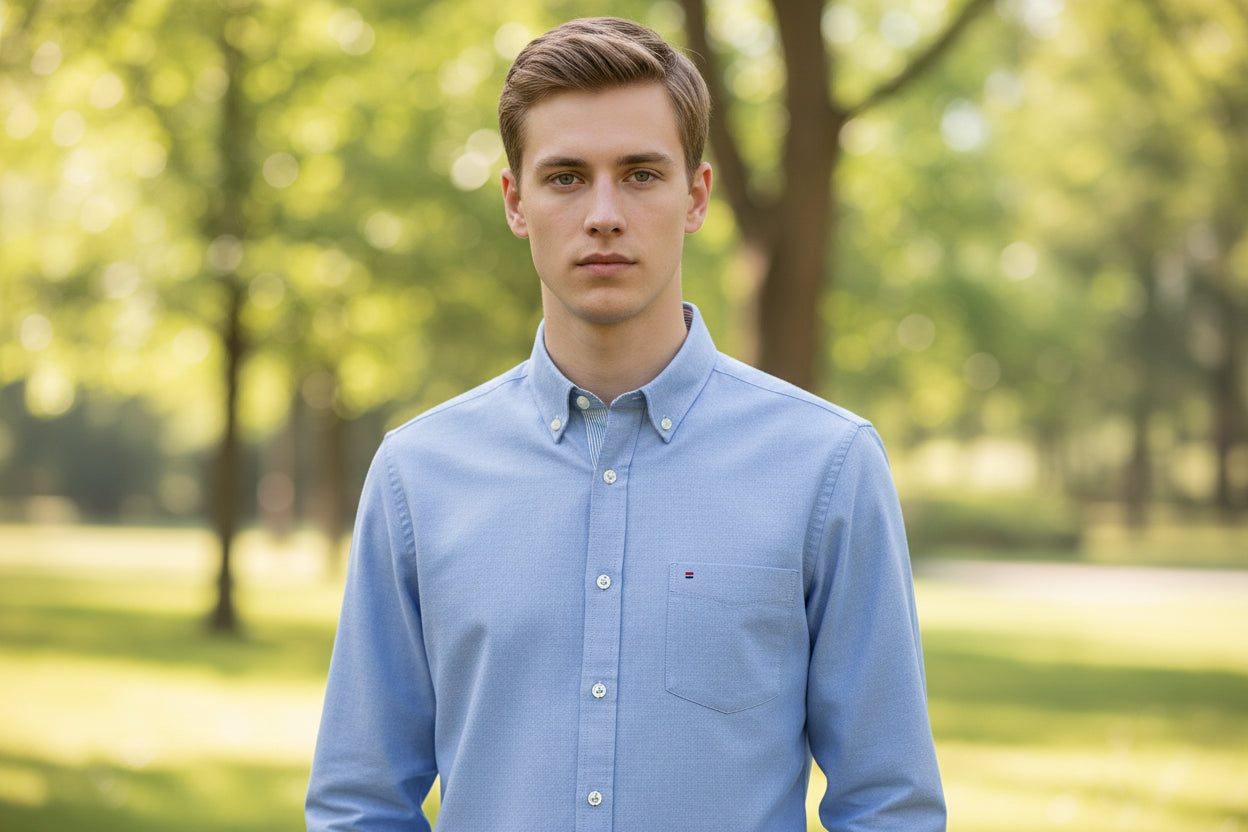 Blue button-up shirt with brand label on a light gray background