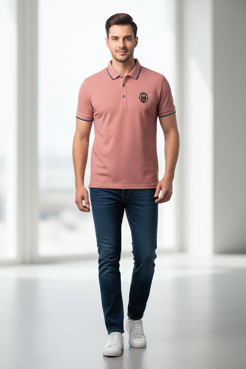 Pink polo shirt with a logo on a gray surface