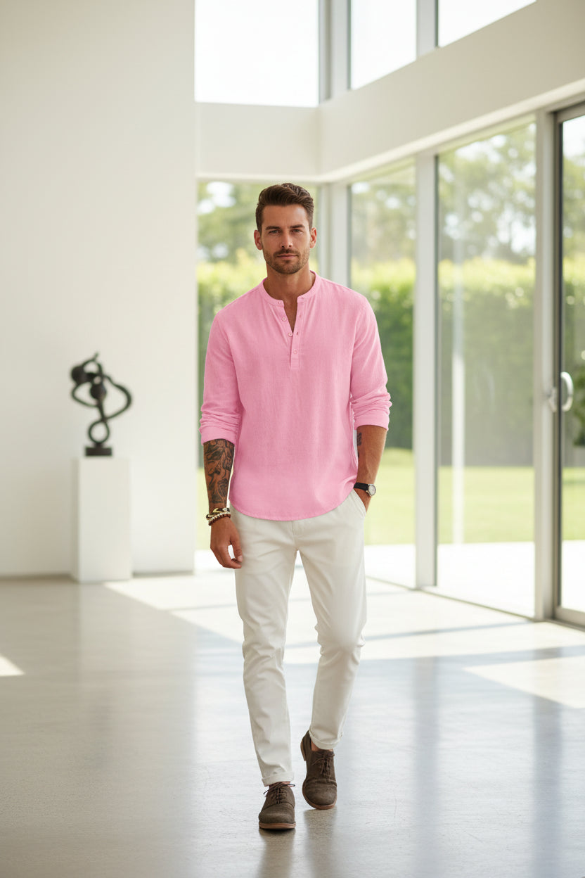 Man wearing a pink long-sleeve shirt and white pants on a white background
