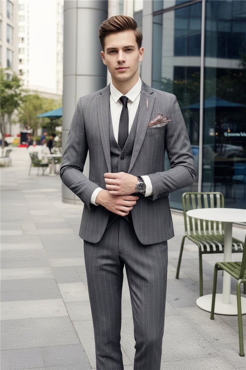 Person wearing a gray suit with a white shirt and black tie in an outdoor setting.