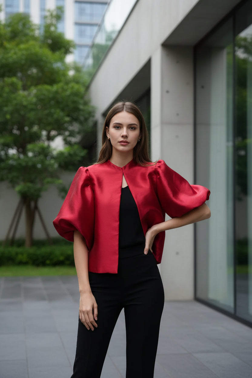 Person wearing a red blouse with puffed sleeves in a bedroom setting