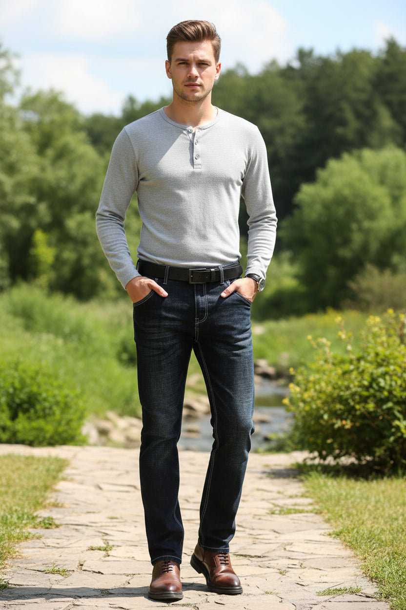 Person wearing dark blue jeans with brown shoes on a light gray background