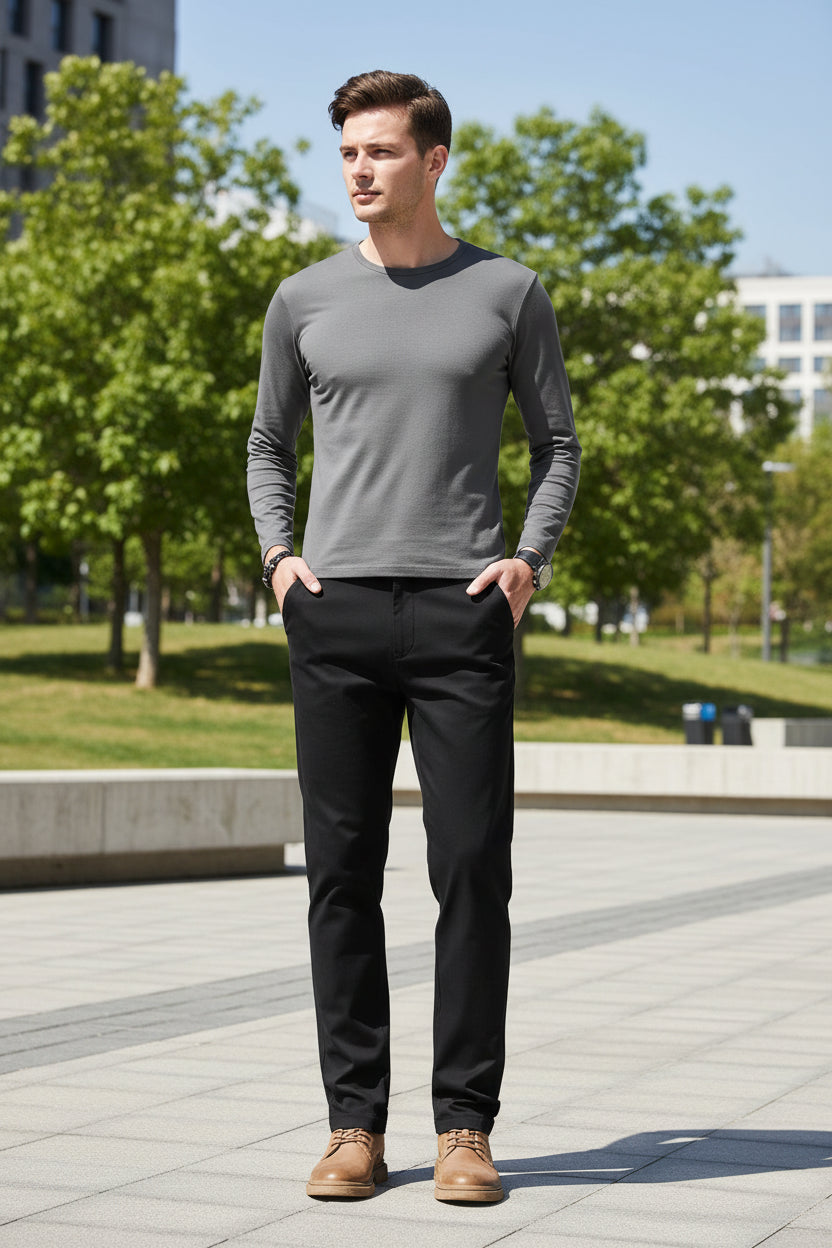 Person wearing black pants and brown shoes on a gray background