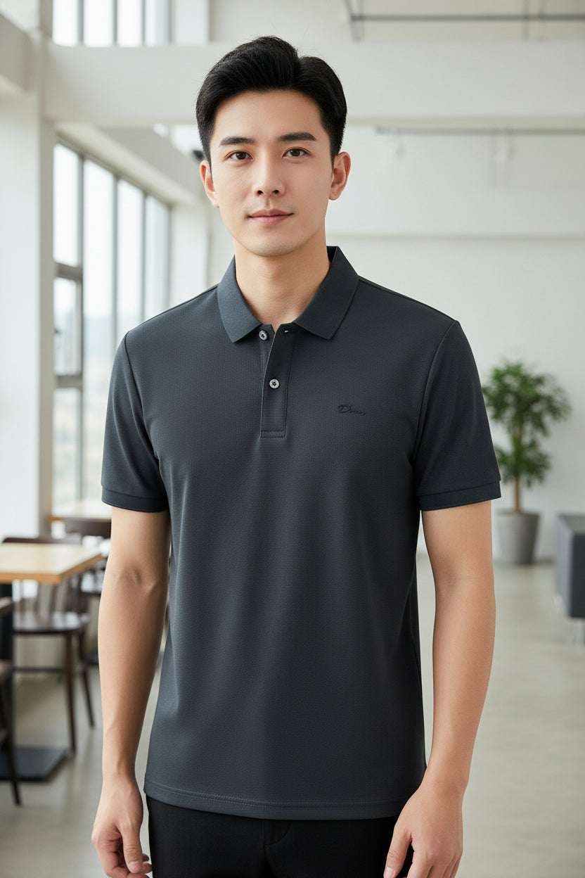 Gray polo shirt held by a hand with a row of folded shirts in the background
