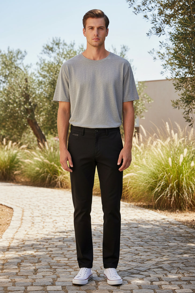 Stack of black summer pants with a visible brand label on a white background