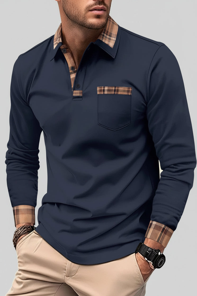 Man wearing a navy long-sleeve polo shirt with plaid accents on a city street.