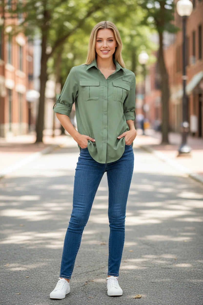 Woman wearing a beige button-up shirt with rolled-up sleeves and blue jeans on a white background